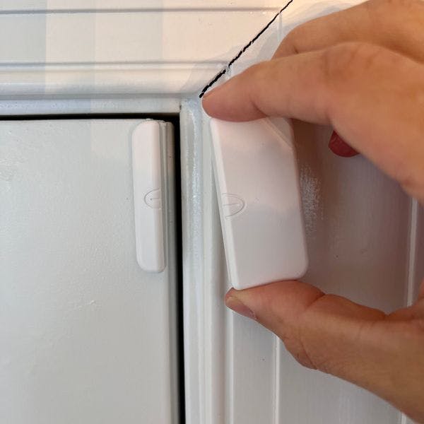 A Cove sensor being installed to a door and frame