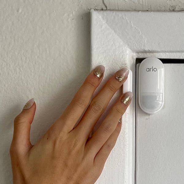 Woman installing all-in-one sensor to door