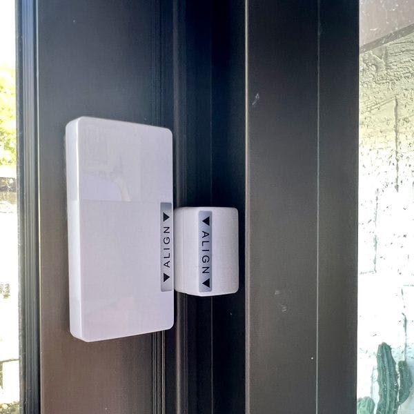 Abode sensor installed to black door frame