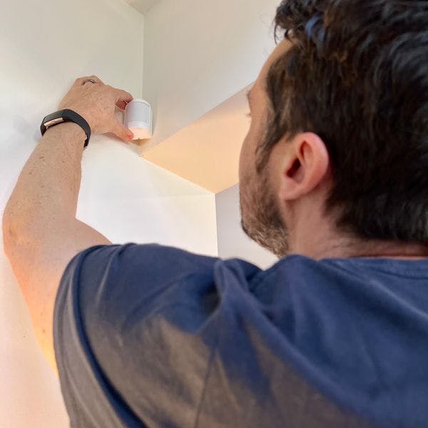 Man installing Cove motion detector