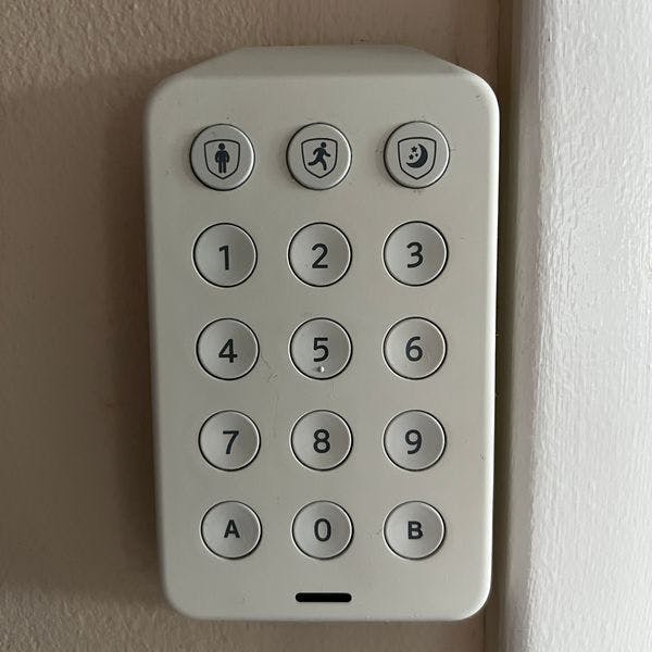 Xfinity home security keypad installed to a beige wall