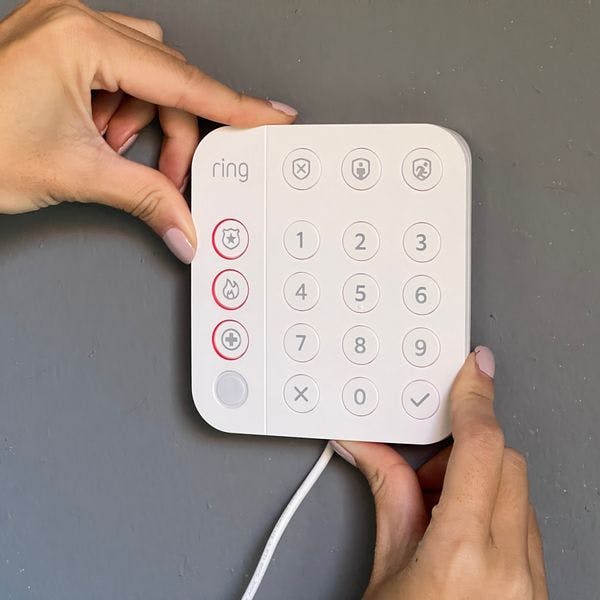 Woman installing her Ring keypad to her wall