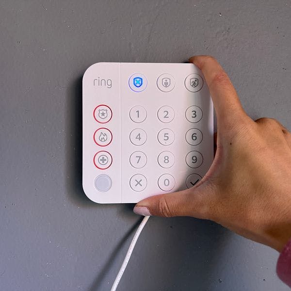 Woman installing her Ring keypad to her wall